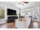 Bright living room with hardwood floors, large windows with lake views, TV, and comfortable seating at 16573 Hutchison Rd, Odessa, FL 33556