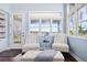 Sitting room featuring hardwood floors, two chairs, tufted ottoman, and view of the water at 16573 Hutchison Rd, Odessa, FL 33556