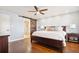 Main bedroom featuring a king size bed, hardwood floors, barn door to bathroom, and two bedside tables at 16573 Hutchison Rd, Odessa, FL 33556