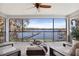 Enjoy gorgeous lake views from this covered patio with a ceiling fan, plush seating, and plenty of natural light at 16573 Hutchison Rd, Odessa, FL 33556