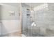 Brightly lit shower area with glass enclosure, tiled walls, built in niche and mosaic shower floor at 16573 Hutchison Rd, Odessa, FL 33556