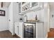 Stylish wet bar with white cabinetry, stone countertops, wine fridge, and sink for entertaining at 16573 Hutchison Rd, Odessa, FL 33556