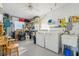 Bright laundry room featuring modern washer, dryer, utility sink, and ample storage shelves and cabinets at 206 Glenellen Pl, Sun City Center, FL 33573