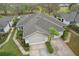 Aerial view of a home showcasing a well-manicured lawn, mature landscaping, and a spacious layout, perfect for comfortable living at 2129 Acadia Greens Dr, Sun City Center, FL 33573
