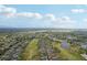 Panoramic aerial captures homes along a golf course dotted with ponds on a bright, partly cloudy day at 2129 Acadia Greens Dr, Sun City Center, FL 33573