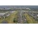 An aerial shot shows a row of houses alongside a community golf course with surrounding ponds at 2129 Acadia Greens Dr, Sun City Center, FL 33573