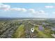 Wide aerial of community homes lining a golf course with ponds, marked with a location pin at 2129 Acadia Greens Dr, Sun City Center, FL 33573
