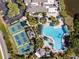 Aerial view of a large community pool with ample seating and nearby pickleball courts at 2129 Acadia Greens Dr, Sun City Center, FL 33573