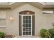 A charming front entryway features a white-framed screen door and decorative exterior lighting at 2129 Acadia Greens Dr, Sun City Center, FL 33573