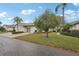 Charming home boasts a well-kept lawn, mature trees, and a two-car garage, creating an inviting curb appeal at 2129 Acadia Greens Dr, Sun City Center, FL 33573