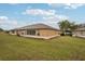 View of the back of the house and backyard with screened patio at 2243 Worthington Greens Dr, Sun City Center, FL 33573