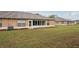 Back of the house featuring a screened in patio and green lawn at 2243 Worthington Greens Dr, Sun City Center, FL 33573