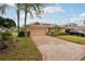 Charming single-story home featuring a well-manicured lawn, mature trees, and an attached two-car garage at 2243 Worthington Greens Dr, Sun City Center, FL 33573
