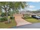 Charming single-story home featuring a well-manicured lawn, mature trees, and an attached two-car garage at 2243 Worthington Greens Dr, Sun City Center, FL 33573