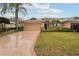 Inviting single-story home with a manicured front lawn, lush landscaping, and an attached two-car garage at 2243 Worthington Greens Dr, Sun City Center, FL 33573