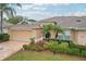 Charming single-story home with a well-kept lawn, beautiful landscaping, and an attached two-car garage at 2243 Worthington Greens Dr, Sun City Center, FL 33573