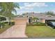 Inviting single-story home with a manicured front lawn, lush landscaping, and an attached two-car garage at 2243 Worthington Greens Dr, Sun City Center, FL 33573