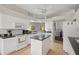 Eat-in kitchen featuring a kitchen island, white appliances, and crisp, white cabinets at 2243 Worthington Greens Dr, Sun City Center, FL 33573
