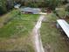 Aerial view of a charming home with a spacious yard, playground, sheds, and barn at 25590 Olympia Rd, Brooksville, FL 34601