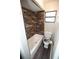 Compact bathroom with tub/shower combo with tile surround, toilet, and a window at 25590 Olympia Rd, Brooksville, FL 34601