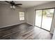 Bright bedroom boasts wood-look floors, a fan, and sliding doors to the backyard at 25590 Olympia Rd, Brooksville, FL 34601