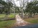 Picturesque driveway entrance framed by wooden fencing and mature trees leading onto the property at 25590 Olympia Rd, Brooksville, FL 34601