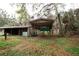 Exterior of a home with a barn and a covered area on a grassy, partially wooded lot at 25590 Olympia Rd, Brooksville, FL 34601