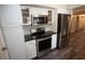 Modern kitchen showcasing stainless steel appliances, white cabinets, and sleek dark countertops at 25590 Olympia Rd, Brooksville, FL 34601