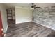 Inviting living room with decorative wood paneling, updated flooring, and a ceiling fan at 25590 Olympia Rd, Brooksville, FL 34601