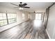 Bright living room featuring modern ceiling fans, barn door, and large windows at 25590 Olympia Rd, Brooksville, FL 34601
