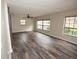 Spacious living room with wood-look floors, neutral paint, ceiling fan and multiple windows at 25590 Olympia Rd, Brooksville, FL 34601