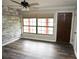 Bright living room featuring a large window, modern ceiling fan, and stylish accent wall, creating a cozy atmosphere at 25590 Olympia Rd, Brooksville, FL 34601