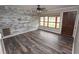 Bright living room with updated flooring, a large window, and a stylish accent wall at 25590 Olympia Rd, Brooksville, FL 34601