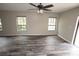 Cozy living room featuring wood-look floors, a ceiling fan, and lots of windows at 25590 Olympia Rd, Brooksville, FL 34601