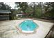 Backyard pool with brick trim, surrounded by a concrete deck and wooden platform perfect for entertaining and outdoor living at 25590 Olympia Rd, Brooksville, FL 34601