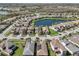 Wide aerial view of closely built homes in a suburban community with a lake and many trees at 30280 Southernwood Ct, Wesley Chapel, FL 33543