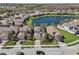 Aerial view of beautiful suburban homes with manicured lawns, and tree lined streets surrounding a peaceful lake at 30280 Southernwood Ct, Wesley Chapel, FL 33543