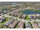 Picturesque aerial shot showcasing a residential neighborhood with a tranquil lake and lush greenery at 30280 Southernwood Ct, Wesley Chapel, FL 33543
