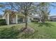 Spacious backyard featuring lush green grass and a covered patio at 30280 Southernwood Ct, Wesley Chapel, FL 33543