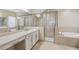 Bathroom with double sink vanity, bathtub, and a glass enclosed shower at 30280 Southernwood Ct, Wesley Chapel, FL 33543