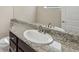 Bathroom featuring granite countertop with oval sink and stylish dark wood cabinets and drawers at 30280 Southernwood Ct, Wesley Chapel, FL 33543