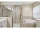Bathroom with a soaking tub, glass shower, and tile surround at 30280 Southernwood Ct, Wesley Chapel, FL 33543