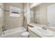 Bright bathroom features tiled walls, a white tub, and a single sink vanity with a large mirror at 30280 Southernwood Ct, Wesley Chapel, FL 33543