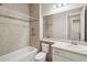 Neutral bathroom with a tub-shower combo, mosaic tile accents, and a single sink vanity at 30280 Southernwood Ct, Wesley Chapel, FL 33543