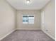 Cozy bedroom featuring neutral walls, carpet flooring, and a bright window at 30280 Southernwood Ct, Wesley Chapel, FL 33543