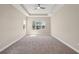 Spacious bedroom featuring a tray ceiling, ceiling fan, and carpet flooring at 30280 Southernwood Ct, Wesley Chapel, FL 33543