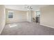 Upstairs bonus room featuring neutral carpet, a ceiling fan, and staircase with iron spindles at 30280 Southernwood Ct, Wesley Chapel, FL 33543