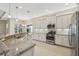 Bright kitchen features white cabinets, granite countertops, stainless steel appliances, and a large window at 30280 Southernwood Ct, Wesley Chapel, FL 33543