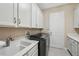 Well-organized laundry room featuring a sink, counter space, cabinets, and modern washer and dryer at 30280 Southernwood Ct, Wesley Chapel, FL 33543