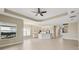 Bright, open floor plan with tile flooring, a ceiling fan, and views of the adjacent kitchen and staircase at 30280 Southernwood Ct, Wesley Chapel, FL 33543